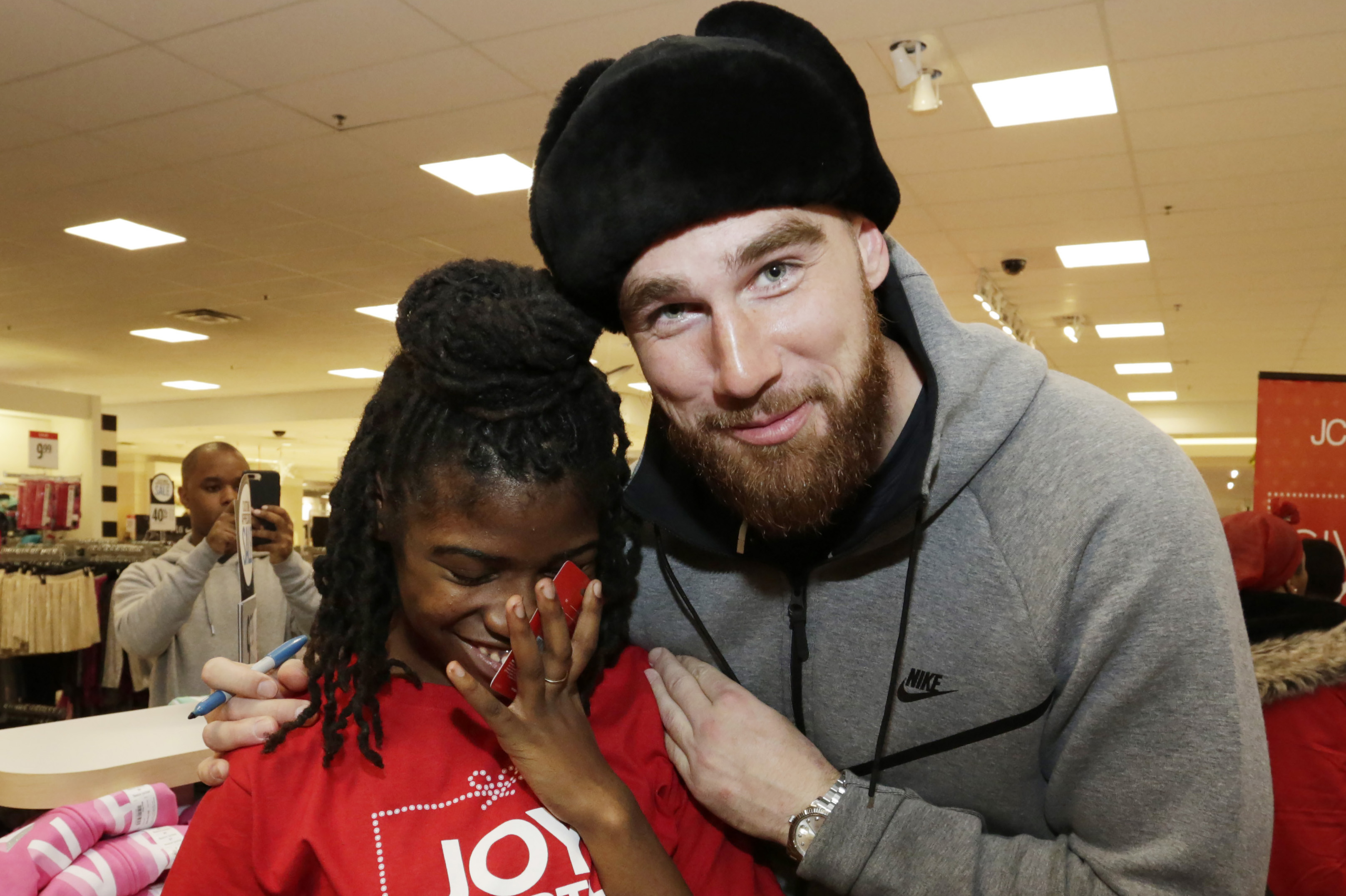 Travis Kelce with child at JCPenny's National Day of Giving